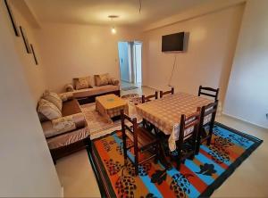 a living room with a table and a couch at Béjaïa 7 Jolis grands Apparts F3-F2 49-69e in Bejaïa