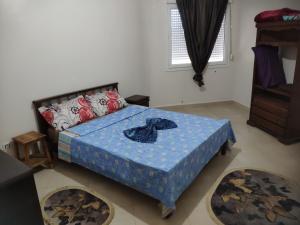 a bedroom with a bed with a blue comforter at Béjaïa 7 Jolis grands Apparts F3-F2 49-69e in Bejaïa