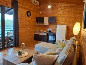 a living room with a couch and a kitchen at Jack Sparrow's cottage- Ada Bojana River in Donji Štoj