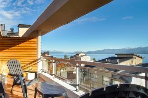 a balcony with a table and chairs on a roof at Balcones al Nahuel II in San Carlos de Bariloche