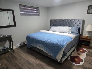 a bedroom with a bed with a blue comforter at Beautiful Home for all in Moncton