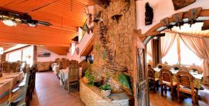 a restaurant with a stone wall and tables and chairs at Smerekova Hata in Yablunytsya