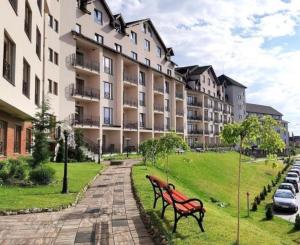 a park with two benches in front of a building at Apartman Larisa in Kopaonik