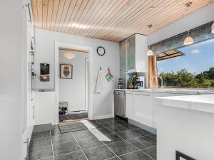 a kitchen with white cabinets and a window at 6 person holiday home in Borre in Borre