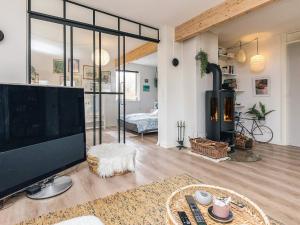 a living room with a large television and a fireplace at 6 person holiday home in Rude in Rude