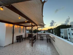 a patio with a table and chairs on a balcony at Casa Dixam Luum in Puerto Morelos