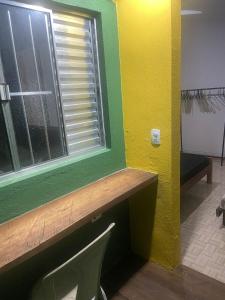 a yellow room with a window and a chair at Morada Vitória in Ubatuba +51 photos