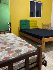 a bedroom with two beds and a window at Morada Vitória in Ubatuba
