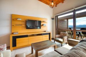 a living room with a couch and a tv at Balcones al Nahuel II in San Carlos de Bariloche