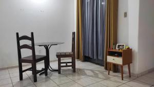 a room with a table and two chairs and a desk at Quarto em Casa Completa no Centro de Ilhéus in Ilhéus +16 photos