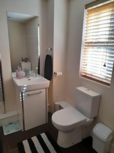 a bathroom with a white toilet and a sink at Comfort Horizon Egham in Egham +16 photos