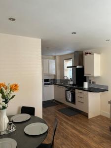 a kitchen with a table and two chairs and a counter at Comfort Horizon Egham in Egham