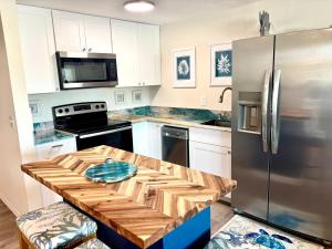 a kitchen with a wooden table and a refrigerator at Beach Front at Ft Myers Beach in Fort Myers Beach