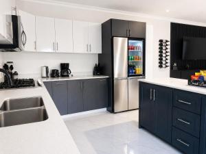 a kitchen with blue cabinets and a stainless steel refrigerator at Redhills Escape in Kingston