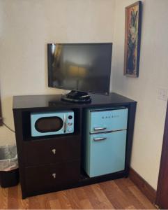 a microwave and a tv on top of a cabinet at Crescent Court in Branson