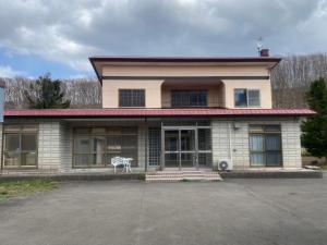 a building with a white bench in front of it at Shiro の秘密基地 駐車場無料 in Ōmagari