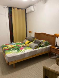 a bedroom with a bed with a floweridered blanket at Maison Petit Paradis in Basse-Terre