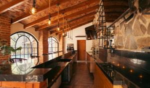 a kitchen with a long counter and a brick wall at Quinta San Ignacio in Guadalajara +6 photos
