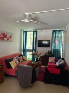 a living room with a red couch and chairs at Maison Petit Paradis in Basse-Terre