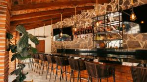 a bar with chairs and a stone wall at Quinta San Ignacio in Guadalajara