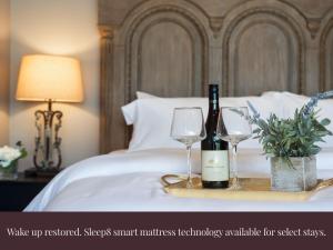 a tray with two glasses and a bottle of wine on a bed at Chic Dallas Retreat Trail, Soaking Tub & Patio in Dallas +32 photos