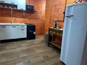 a kitchen with a white refrigerator and a stove at El Regreso in Chuí +3 photos