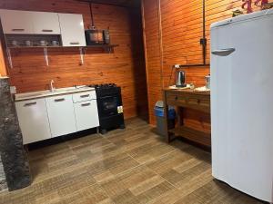a kitchen with a white refrigerator and a stove at El Regreso in Chuí