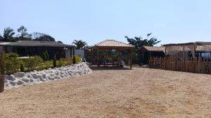 a gravel driveway with a fence and a pavilion at Estância Serra Du Capiau 01 in Mairiporã