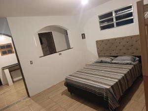 a bedroom with a bed in a room with a mirror at Estância Serra Du Capiau 01 in Mairiporã +15 photos