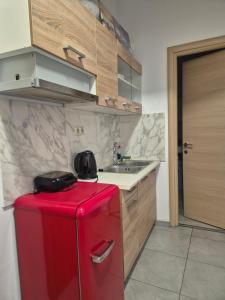 a red refrigerator in a kitchen with a sink at Castle View #3-4 in Kavála