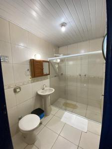 a bathroom with a shower and a toilet and a sink at Pousada Ypê Amarelo in Itatiaia +35 photos