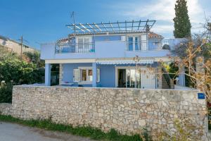 a house behind a stone wall at Apartments by the sea Maslinica, Solta - 14748 in Maslinica