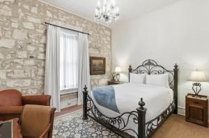 a bedroom with a bed and a chair at Shopkeeper's Inn in Fredericksburg