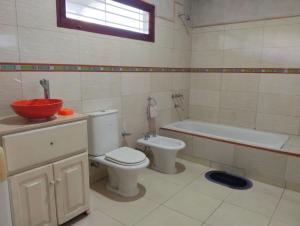 a bathroom with a toilet and a tub and a sink at Suite Premium Perico Jujuy con Parking in Establecimiento La Candelaria