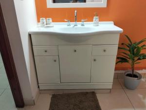 a bathroom with a white sink and a plant at Suite Premium Perico Jujuy con Parking in Establecimiento La Candelaria