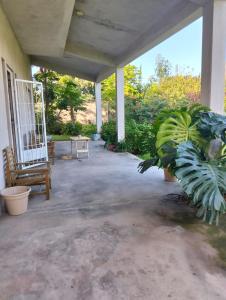 a porch of a house with a bench and plants at Suite Premium Perico Jujuy con Parking in Establecimiento La Candelaria +7 photos