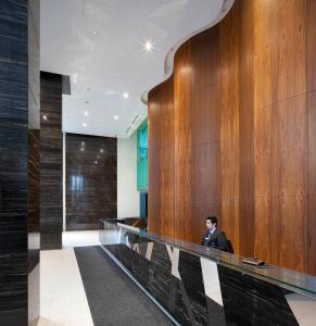 a man in a suit sitting in a lobby at Toronto Harbourview Suites with free parking in Toronto