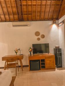 a living room with a television and a table at The SUN House in Balian