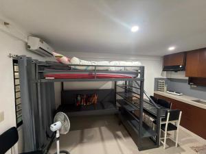 a bunk bed in a room with a desk and a fan at stayhouse in Gapan