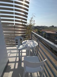 a patio with two chairs and a table on a balcony at stayhouse in Gapan