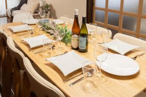 a wooden table with wine bottles and glasses on it at Staylinks Nara Kitamachi in Nara