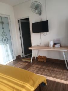 a room with a bed and a tv on the wall at MyHouse in Da Lat