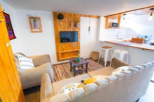 a living room with a couch and a kitchen at Sosa Andina House in Huaraz