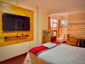 a bedroom with a flat screen tv on a wall at Sosa Andina House in Huaraz