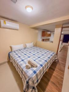 a bedroom with a bed with a blue and white plaid blanket at Amaizing view Islas Marietas in Punta Mita
