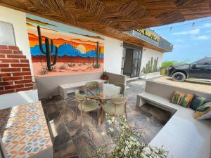 a living room with a table and a painting on the wall at Bora Bora Hostal y Pasadías in Manaure