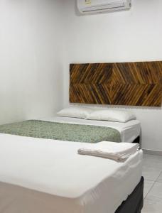 two beds sitting next to each other in a room at Bora Bora Hostal y Pasadías in Manaure