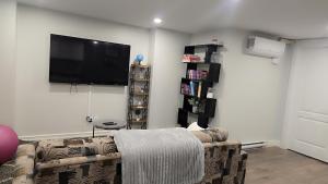 a living room with a couch and a flat screen tv at Beautiful Home for all in Moncton