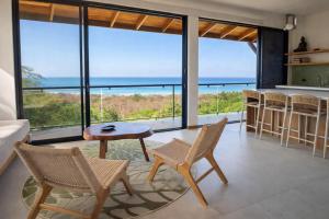 a living room with a view of the ocean at Vista Naranja Retreat in Santa Teresa Beach +21 photos