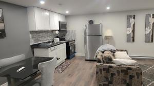 a kitchen with a couch and a table and a refrigerator at Beautiful Home for all in Moncton